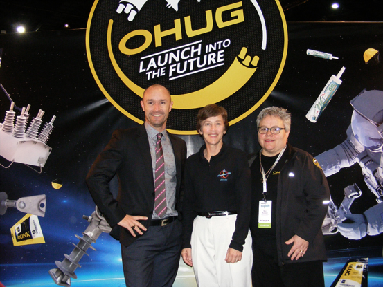 La astronauta retirada de la NASA, Wendy B. Lawrence, en el stand temático del universo, perteneciente al distribuidor de NOJA Power en Nueva Zelanda, OHUG, en la conferencia de EEA junto con Glenn Harris de NOJA Power y Nan Russel de OHUG